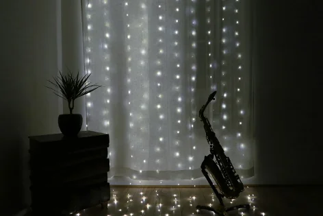 A picture of a saxophone in moodlight, dark with sparkly lights behind.